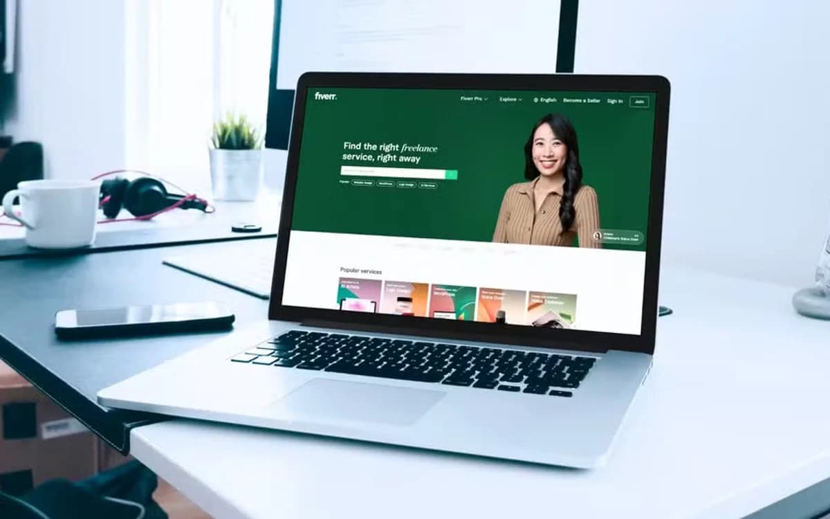 Laptop aberto na página inicial da Fiverr em mesa de trabalho